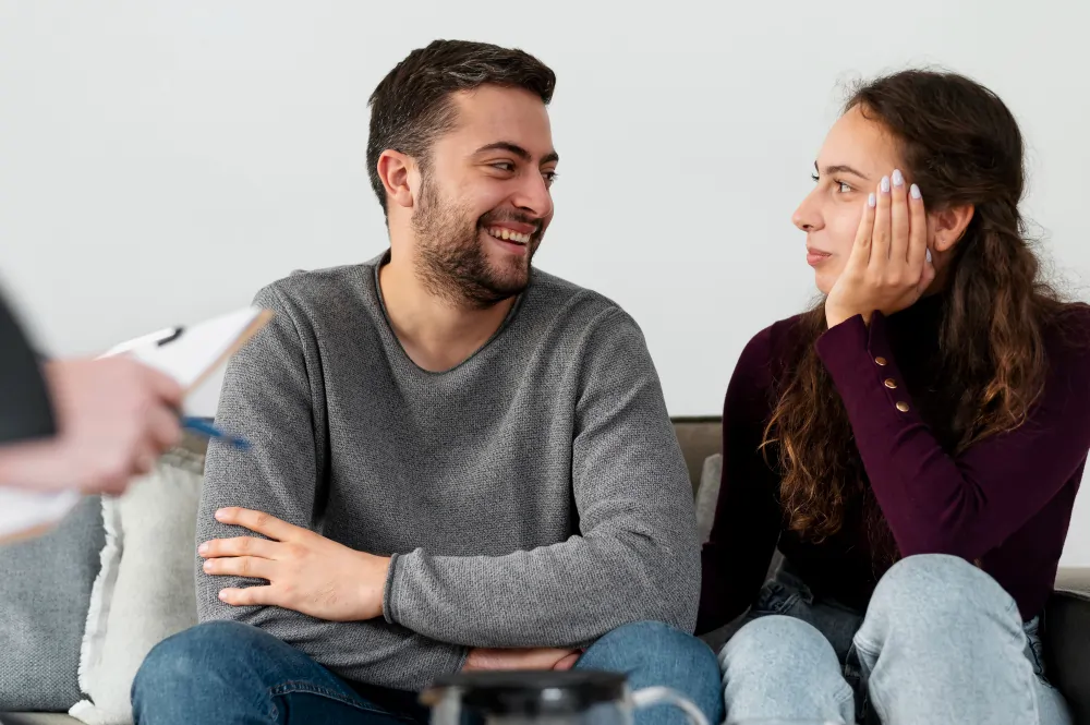 A couple smiling and in conversation during a relationship therapy session with a UKCP psychotherapist in London.