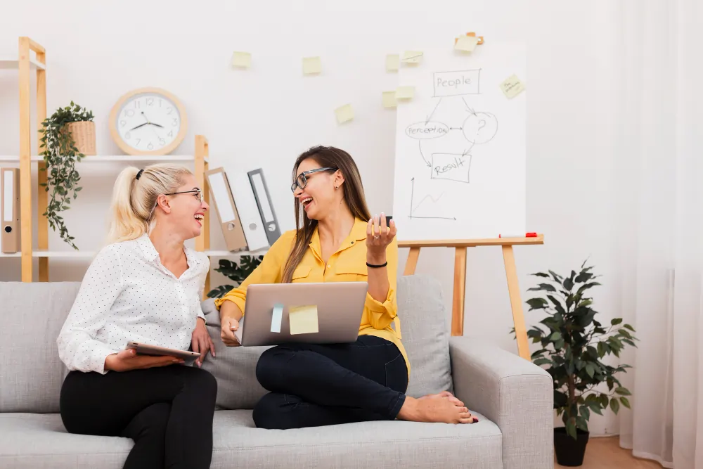 A one-to-one mindset coaching session with a thinking-pattern diagram on a flipchart in the background.