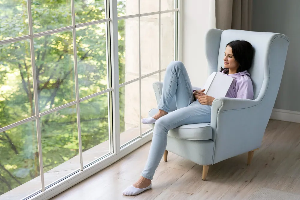 Woman reflecting calmly in an armchair by a bright window while choosing a BPD therapist in London