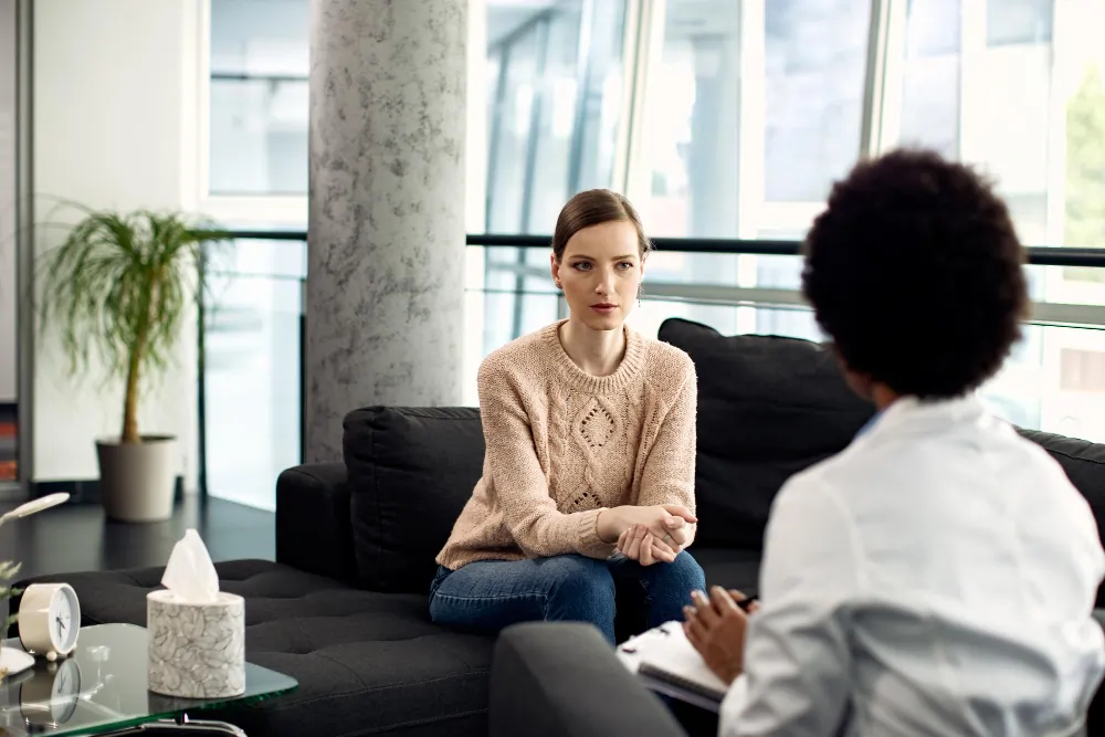 A young person in a calm, professional therapy session with a therapist. Featured image for the post "PTSD Therapy in London: A Guide to Finding Trauma-Focused Care"